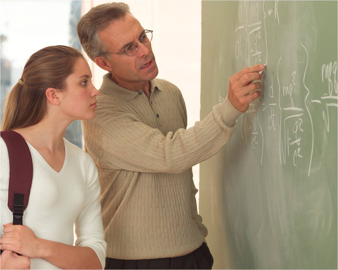 Interpersonal communications Teacher helping student at blackboard